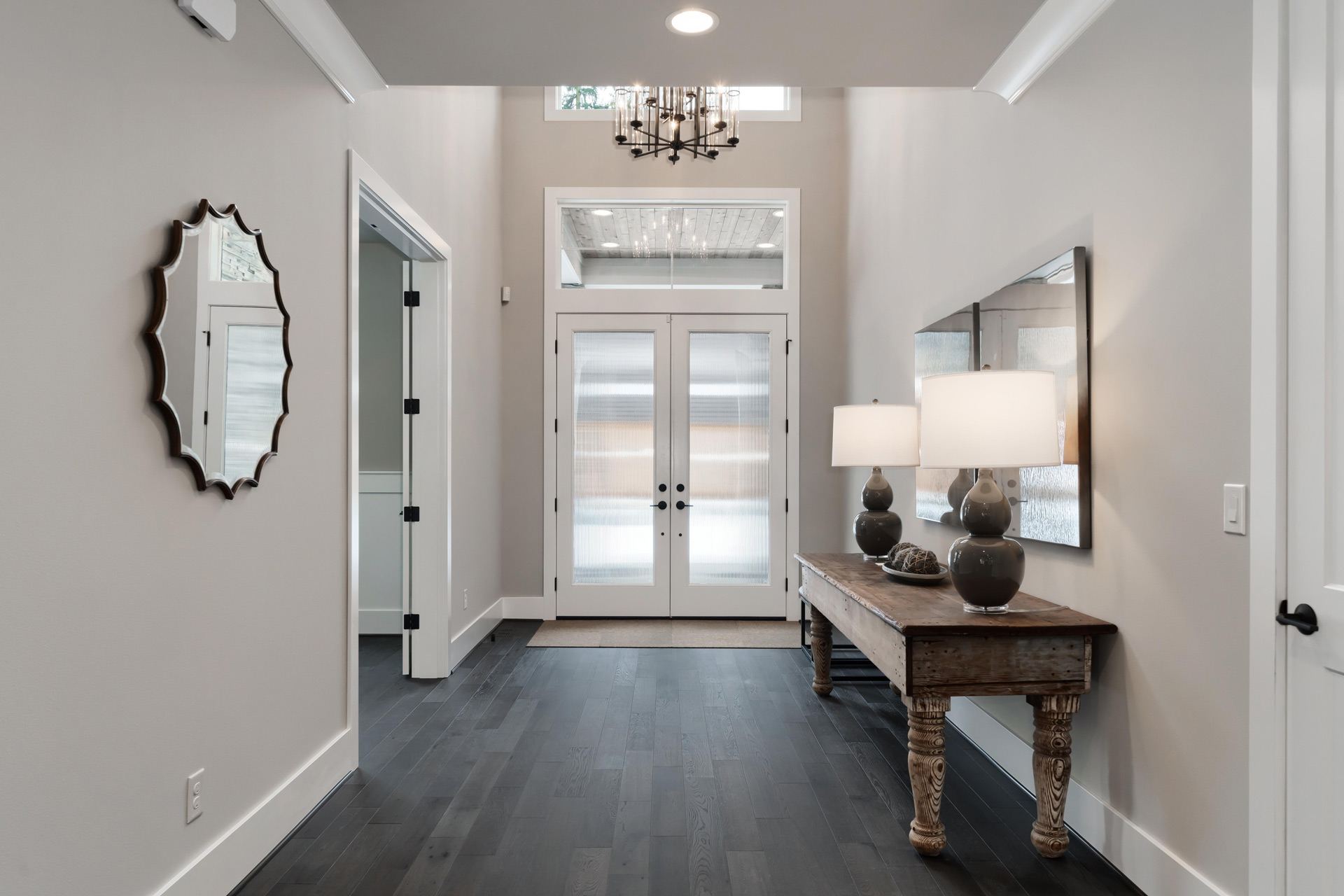 Bright entrance with wooden flooring and an antique console table, from LF Immo.